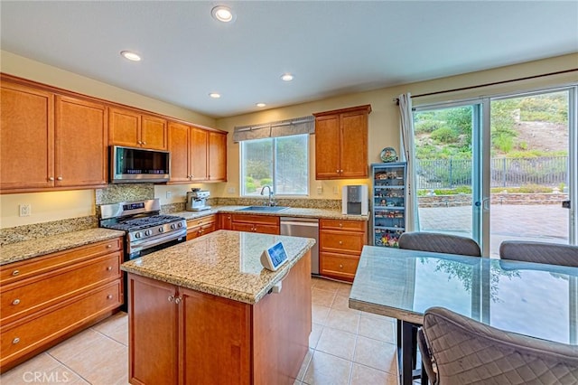 25238 Gloriso Ln, Stevenson Ranch, CA 91381 - kitchen with appliances with stainless steel finishes, a sink, light stone counters, light tile patterned floors, and recessed lighting