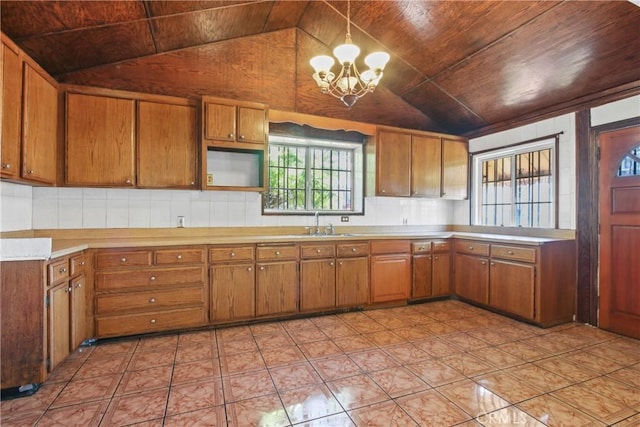 1419 S Redondo Blvd, Los Angeles, CA 90019 - kitchen with brown cabinetry, a chandelier, vaulted ceiling, wooden ceiling, and light countertops
