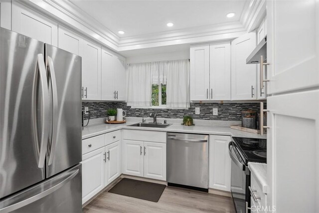 3241 San Amadeo Unit 1G, Laguna Woods, CA 92637 - kitchen featuring appliances with stainless steel finishes, a sink, crown molding, under cabinet range hood, and light countertops