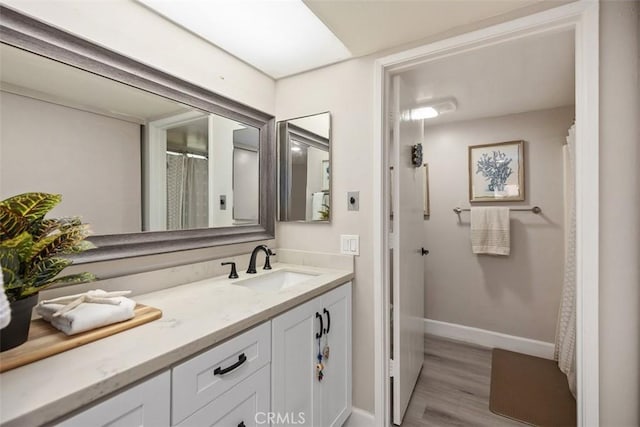 3241 San Amadeo Unit 1G, Laguna Woods, CA 92637 - bathroom featuring vanity, wood finished floors, and baseboards