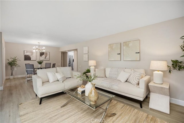 3241 San Amadeo Unit 1G, Laguna Woods, CA 92637 - living area featuring baseboards, a chandelier, and wood finished floors