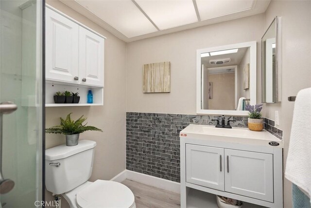 3241 San Amadeo Unit 1G, Laguna Woods, CA 92637 - bathroom with vanity, toilet, wood finished floors, a shower, and baseboards