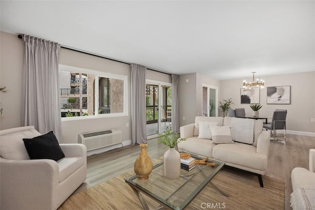 3241 San Amadeo Unit 1G, Laguna Woods, CA 92637 - living area featuring wood finished floors, a chandelier, baseboards, and a wall unit AC
