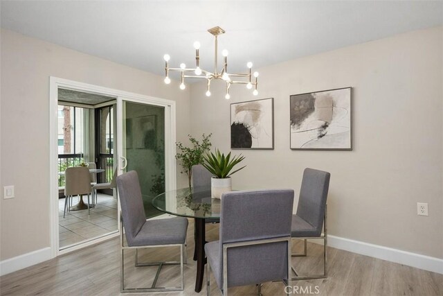 3241 San Amadeo Unit 1G, Laguna Woods, CA 92637 - dining space with wood finished floors, a chandelier, and baseboards