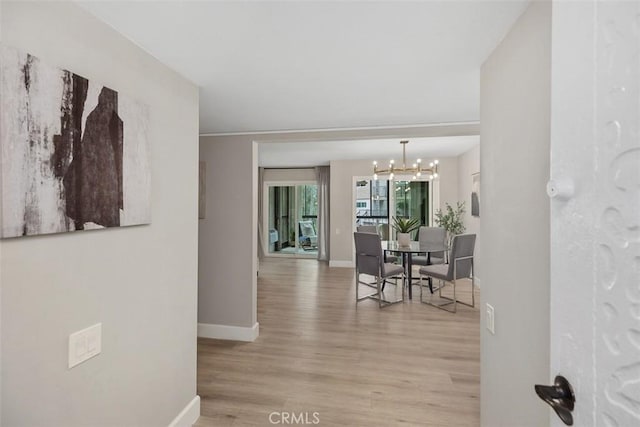 3241 San Amadeo Unit 1G, Laguna Woods, CA 92637 - dining space featuring baseboards, wood finished floors, and a chandelier