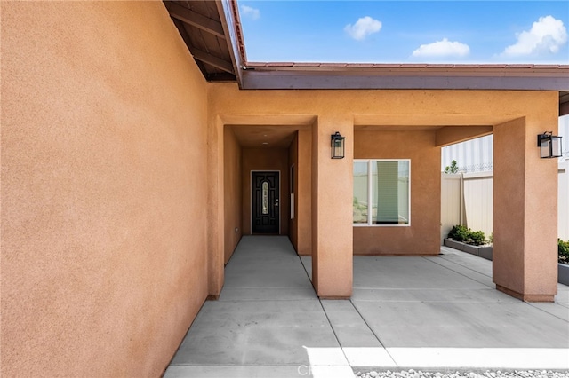 1243 Ansley Ln, Mentone, CA 92359 - view of exterior entry with stucco siding and a patio area