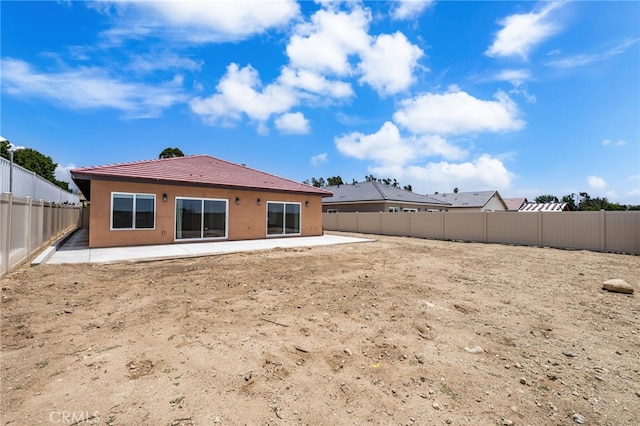 1243 Ansley Ln, Mentone, CA 92359 - back of property featuring a patio, a tiled roof, stucco siding, and a fenced backyard