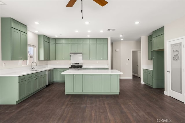 1243 Ansley Ln, Mentone, CA 92359 - kitchen featuring green cabinetry, appliances with stainless steel finishes, a center island, dark wood finished floors, and ceiling fan