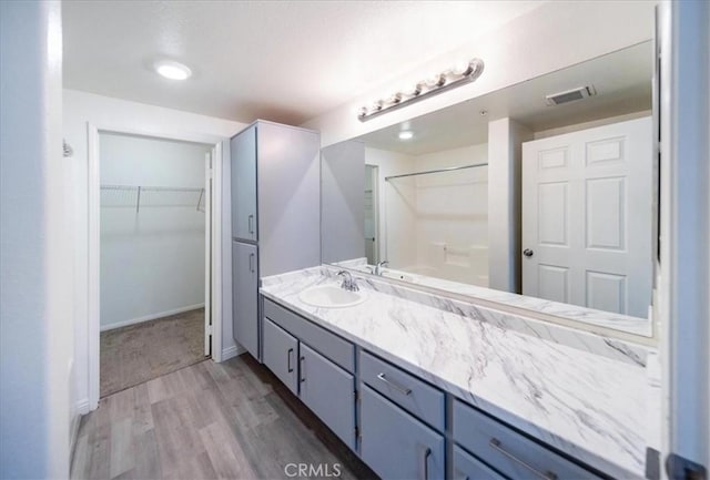 31241 Taylor Ln, Temecula, CA 92592 - full bathroom with wood finished floors, vanity, a spacious closet, and baseboards