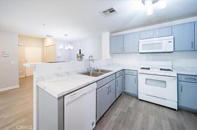 31241 Taylor Ln, Temecula, CA 92592 - kitchen with white appliances, a sink, a peninsula, light wood-style flooring, and light countertops