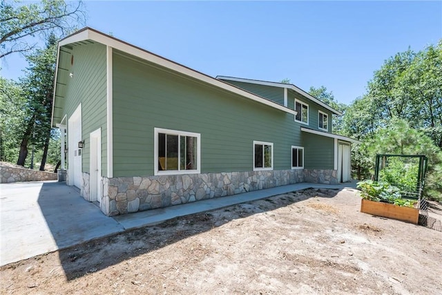32557 Pine Cone Ct Unit A & B, Running Springs, CA 92382 - view of side of home with stone siding and a vegetable garden