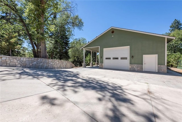 32557 Pine Cone Ct Unit A & B, Running Springs, CA 92382 - view of property exterior featuring a garage, driveway, an outdoor structure, and stone siding