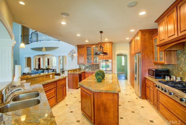 32557 Pine Cone Ct Unit A & B, Running Springs, CA 92382 - kitchen featuring stainless steel appliances, a sink, brown cabinetry, a kitchen island, and tasteful backsplash