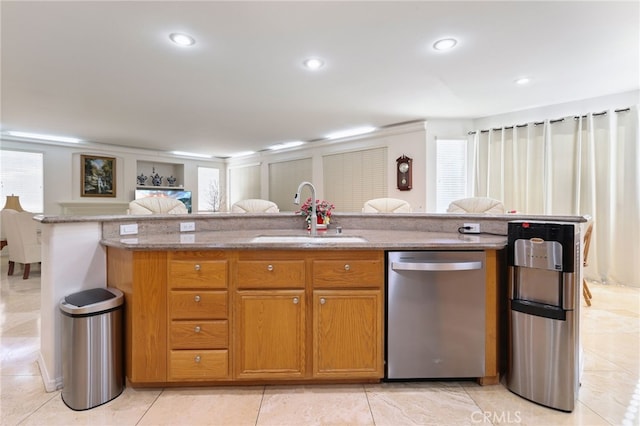 12830 Wildflower Ln, Riverside, CA 92503 - kitchen with stainless steel dishwasher, a sink, light stone counters, open floor plan, and brown cabinetry