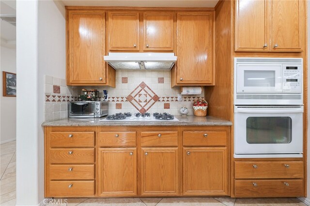 12830 Wildflower Ln, Riverside, CA 92503 - kitchen featuring under cabinet range hood, white appliances, tasteful backsplash, and light stone countertops