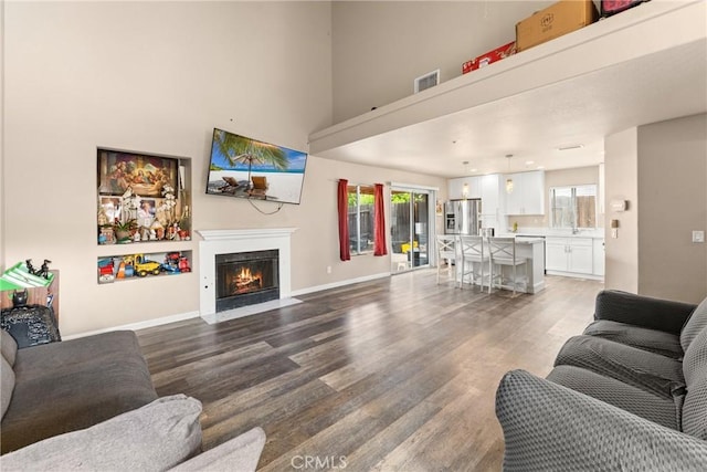1149 Cochise Ct, Vista, CA 92084 - living room featuring wood finished floors, a high ceiling, plenty of natural light, a fireplace with flush hearth, and baseboards