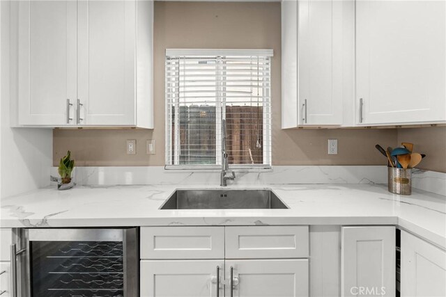 1149 Cochise Ct, Vista, CA 92084 - kitchen featuring beverage cooler, a sink, white cabinetry, and light stone countertops