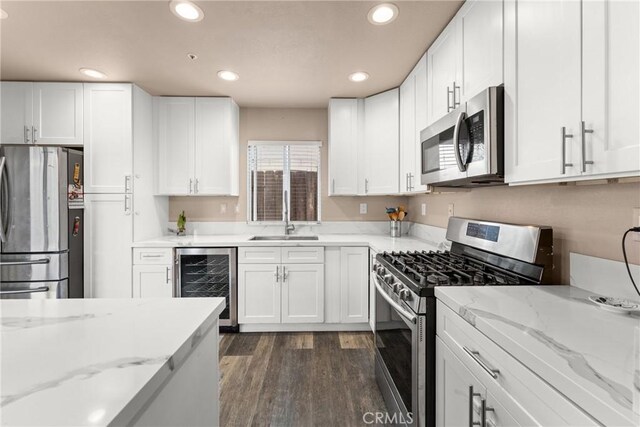 1149 Cochise Ct, Vista, CA 92084 - kitchen featuring appliances with stainless steel finishes, wine cooler, a sink, recessed lighting, and white cabinets