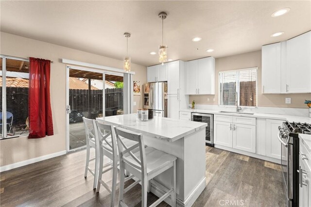 1149 Cochise Ct, Vista, CA 92084 - kitchen featuring beverage cooler, stainless steel appliances, wood finished floors, a kitchen breakfast bar, and recessed lighting