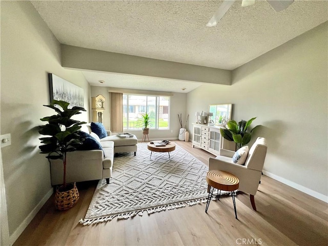 13580 Medinac Ln Unit M5-E, Seal Beach, CA 90740 - living room featuring wood finished floors, baseboards, a textured ceiling, and ceiling fan