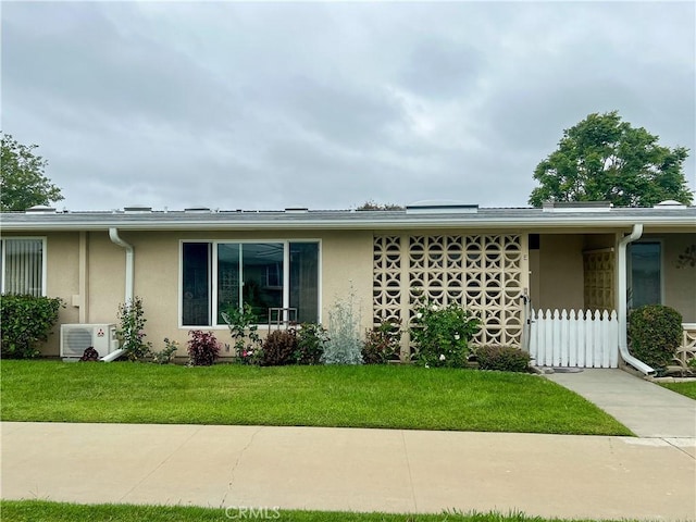 13580 Medinac Ln Unit M5-E, Seal Beach, CA 90740 - view of front of house featuring stucco siding, a cooling unit, and a front yard