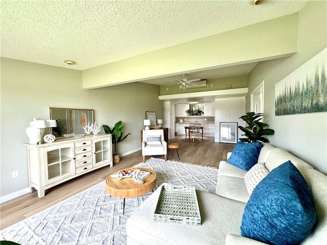 13580 Medinac Ln Unit M5-E, Seal Beach, CA 90740 - living area featuring a ceiling fan, wood finished floors, a textured ceiling, and baseboards