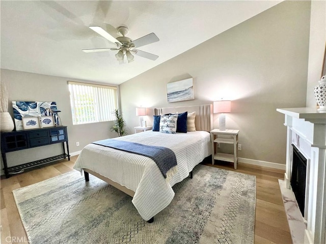 13580 Medinac Ln Unit M5-E, Seal Beach, CA 90740 - bedroom with baseboards, vaulted ceiling, light wood finished floors, ceiling fan, and a fireplace