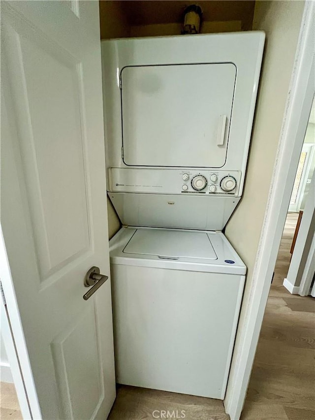 13580 Medinac Ln Unit M5-E, Seal Beach, CA 90740 - washroom with stacked washing machine and dryer and light wood-style flooring