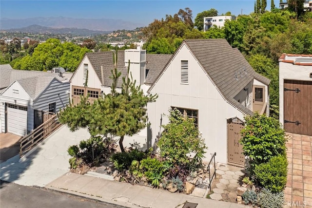 2376 Lake View Ave, Los Angeles, CA 90039 - view of front facade with board and batten siding, roof with shingles, a chimney, and a mountain view