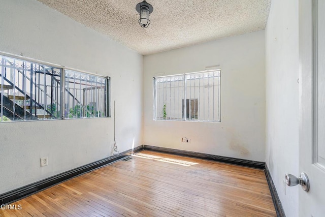 332 N St Louis St, Los Angeles, CA 90033 - unfurnished room featuring wood-type flooring, a textured ceiling, and baseboards