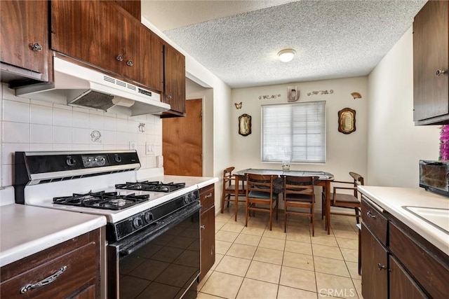 556 San Marino St, Hemet, CA 92545 - kitchen with white gas stove, under cabinet range hood, tasteful backsplash, light countertops, and light tile patterned flooring