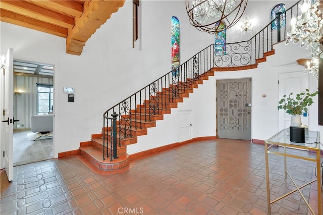 1812 Linda Vista Ave, Pasadena, CA 91103 - staircase with a chandelier, a high ceiling, baseboards, beamed ceiling, and tile patterned flooring