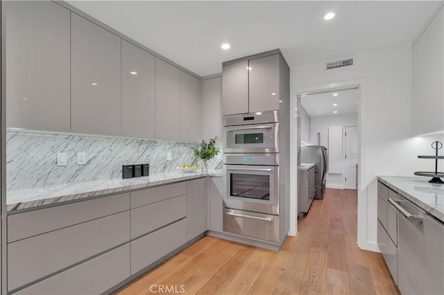 1812 Linda Vista Ave, Pasadena, CA 91103 - kitchen with gray cabinets, modern cabinets, a warming drawer, washing machine and dryer, and stainless steel double oven