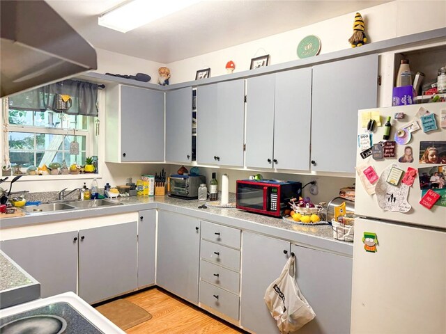 216 College Ave, Weed, CA 96094 - kitchen featuring freestanding refrigerator, a sink, light countertops, light wood-style flooring, and white cabinetry