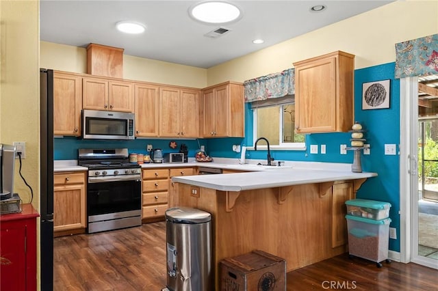 4930 Contentment Ln, Forest Ranch, CA 95942 - kitchen featuring appliances with stainless steel finishes, dark wood finished floors, a sink, a peninsula, and light countertops
