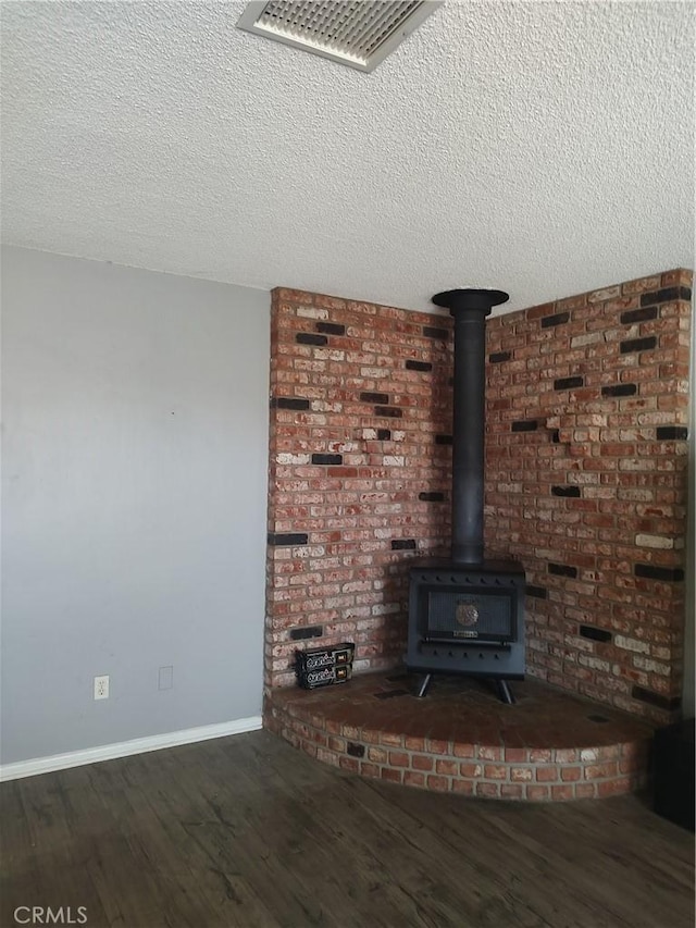7870 Hopi Trl, Yucca Valley, CA 92284 - detailed view of wood finished floors, a wood stove, and a textured ceiling
