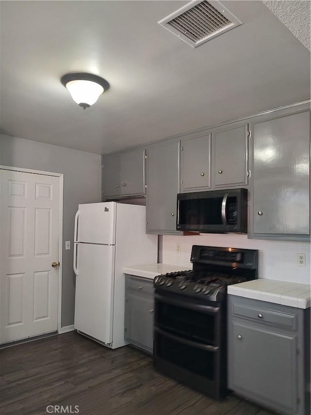 7870 Hopi Trl, Yucca Valley, CA 92284 - kitchen with gray cabinets, black appliances, tile counters, and dark wood-type flooring