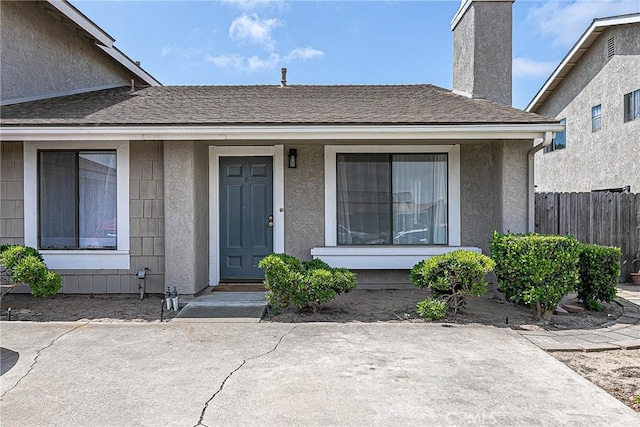 1168 E Foster Rd Unit B, Santa Maria, CA 93455 - doorway to property with a chimney, stucco siding, a shingled roof, and a porch