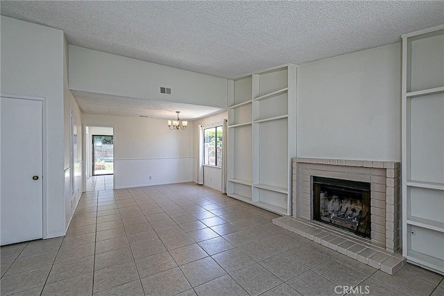1168 E Foster Rd Unit B, Santa Maria, CA 93455 - unfurnished living room with a textured ceiling, a chandelier, a brick fireplace, light tile patterned floors, and built in features