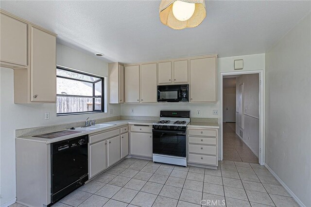1168 E Foster Rd Unit B, Santa Maria, CA 93455 - kitchen featuring black appliances, light countertops, cream cabinetry, light tile patterned floors, and a textured ceiling