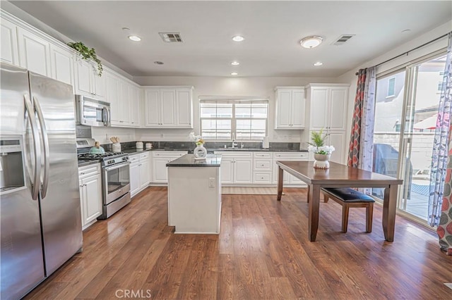 21836 Moveo Dr, Saugus, CA 91350 - kitchen with stainless steel appliances, healthy amount of natural light, dark countertops, white cabinets, and recessed lighting