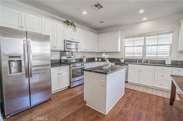 21836 Moveo Dr, Saugus, CA 91350 - kitchen with stainless steel appliances, white cabinetry, a center island, dark wood-style floors, and recessed lighting