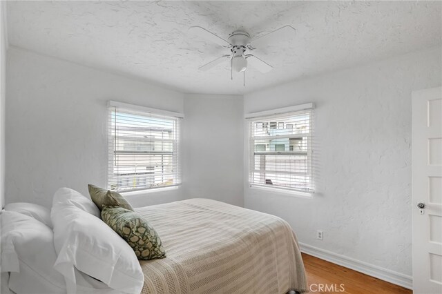 2468 Silverstrand Ave, Hermosa Beach, CA 90254 - bedroom featuring wood finished floors, multiple windows, and a ceiling fan