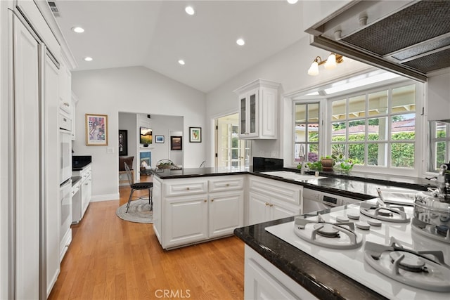 1162 Castlegate, North Tustin, CA 92705 - kitchen with white appliances, a sink, a peninsula, white cabinetry, and lofted ceiling