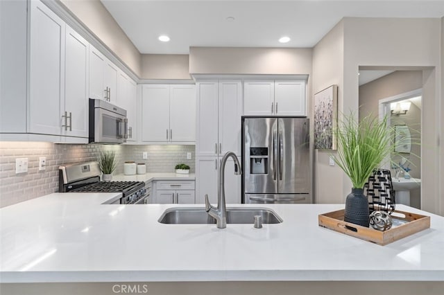78 Patria, Rancho Mission Viejo, CA 92694 - kitchen featuring stainless steel appliances, light countertops, decorative backsplash, white cabinetry, and a peninsula