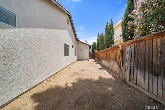 26577 Trumble Rd, Menifee, CA 92585 - view of side of home with stucco siding, a fenced backyard, and a patio