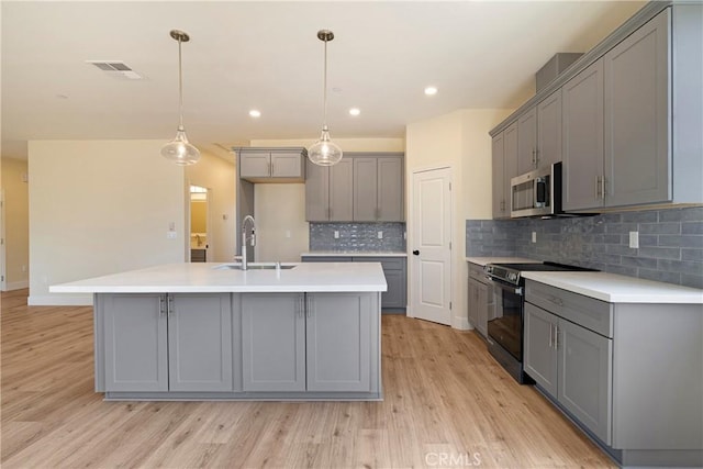 2395 Tokay Ct, Paradise, CA 95969 - kitchen featuring gray cabinets, electric range, a sink, stainless steel microwave, and light wood finished floors