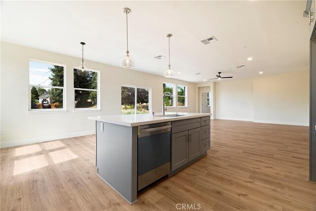 2395 Tokay Ct, Paradise, CA 95969 - kitchen with stainless steel dishwasher, a sink, gray cabinetry, light wood-style floors, and recessed lighting