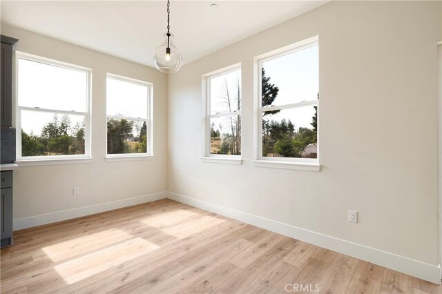 2395 Tokay Ct, Paradise, CA 95969 - unfurnished dining area featuring baseboards, plenty of natural light, and light wood-style flooring