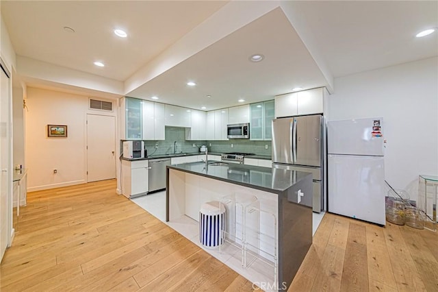 4813 Oakwood Ave Unit 201, Los Angeles, CA 90004 - kitchen featuring stainless steel appliances, modern cabinets, dark countertops, white cabinets, and light wood-style flooring